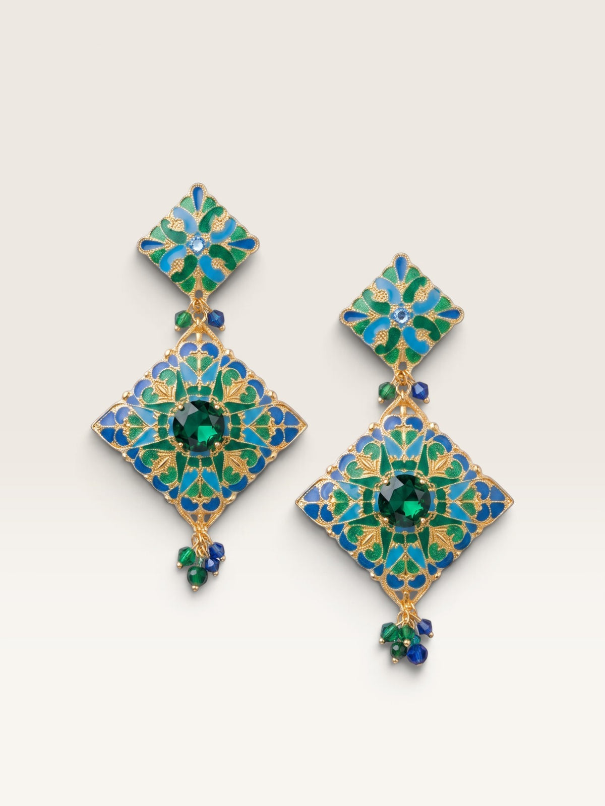Pendientes Sergy & Tapiju esmaltados a mano en tonos azul y verde con base de acero dorado y cuentas de cristal.