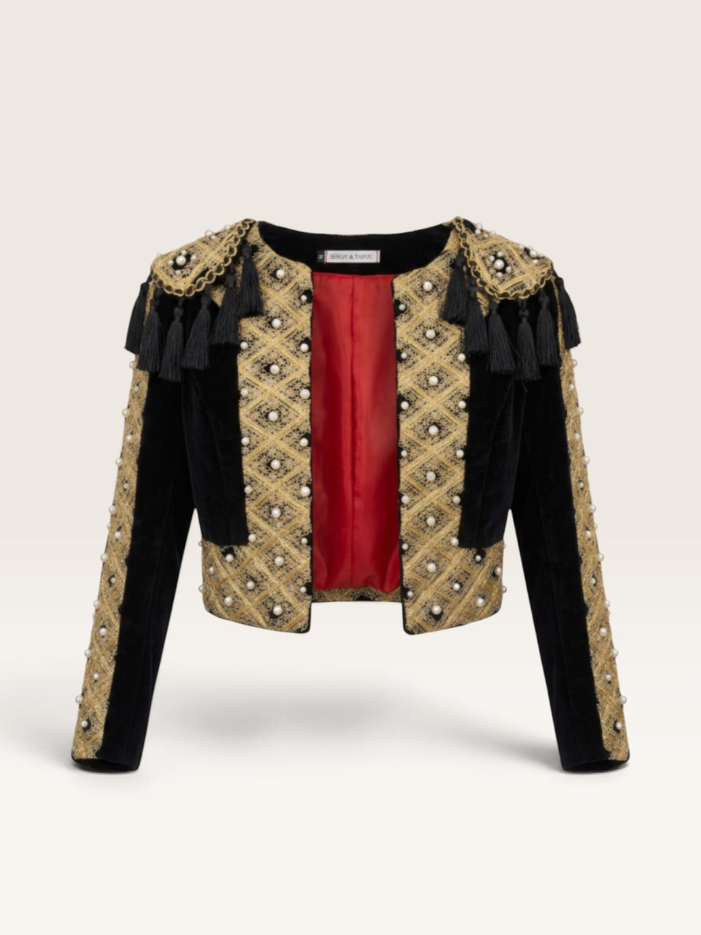 Torera negra de terciopelo Sergy & Tapiju con bordados dorados, perlas y forro rojo, estilo torero artesanal.
