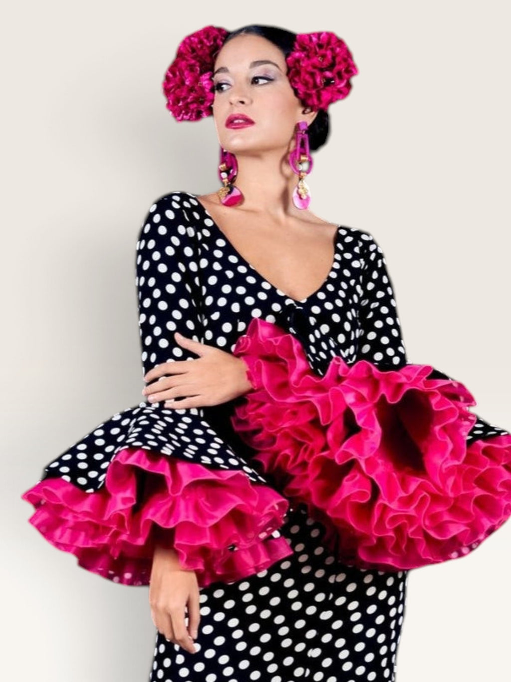 Traje de flamenca Sergy & Tapiju negro con lunares blancos, escote pico y volantes fucsia en mangas y bajo