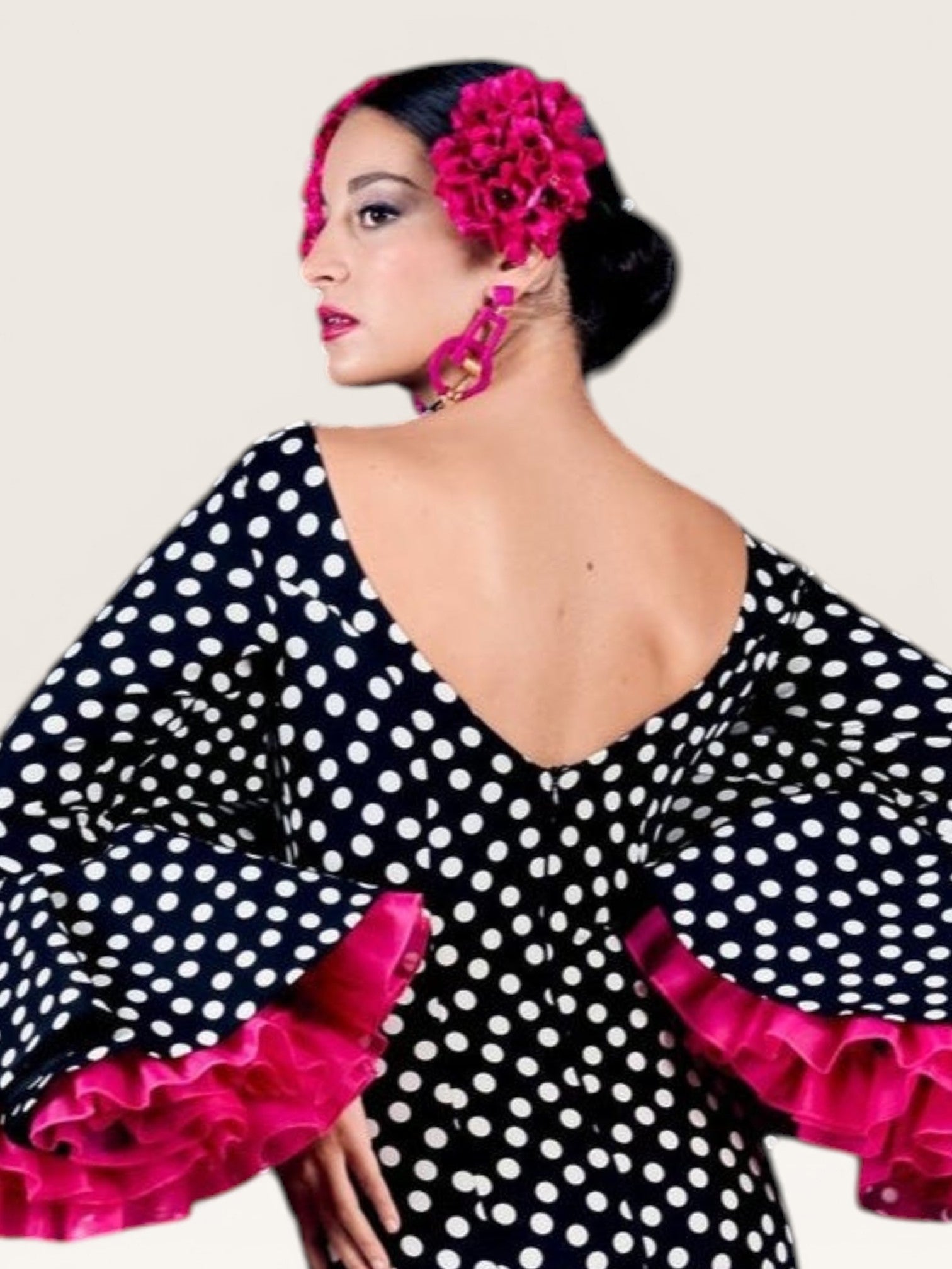 Traje de flamenca Sergy & Tapiju negro con lunares blancos, escote en pico y volantes fucsias en mangas y bajo
