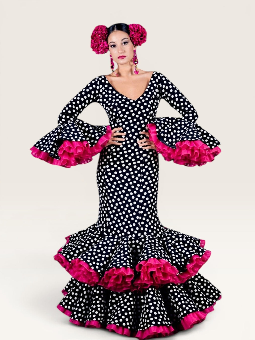 Traje de flamenca Sergy & Tapiju con estampado de lunares, escote en pico y volantes fucsias en mangas y bajo.