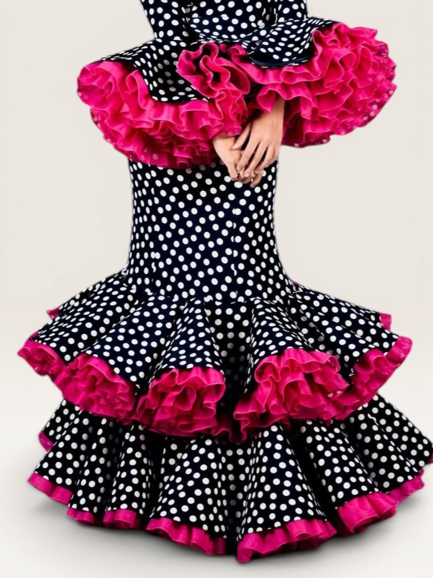 Traje de flamenca Sergy & Tapiju con estampado de lunares blancos sobre fondo negro y volantes fucsias