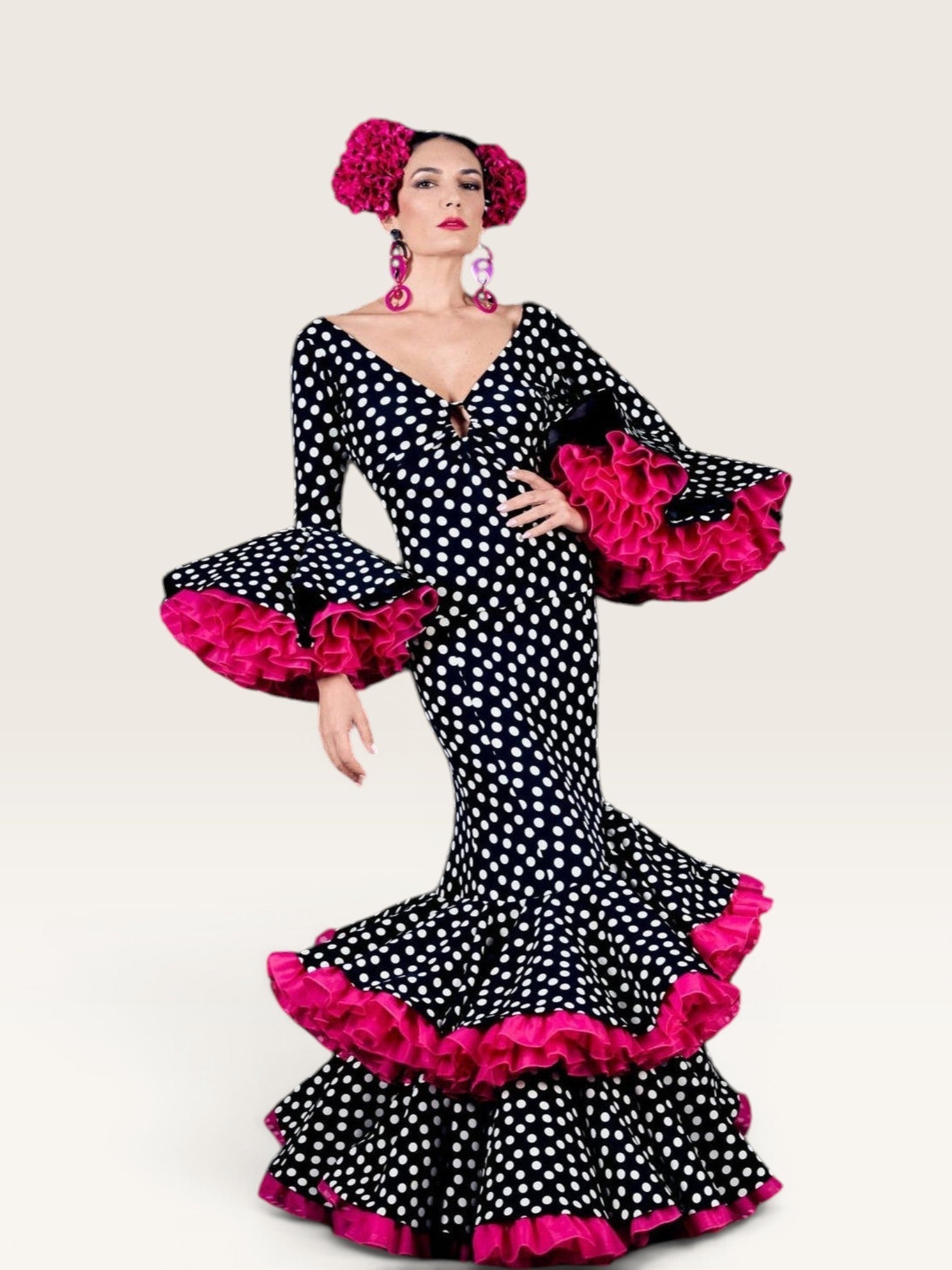 Modelo con vestido de flamenca Sergy & Tapiju negro con lunares blancos, escote en V y volantes fucsia en mangas y bajo