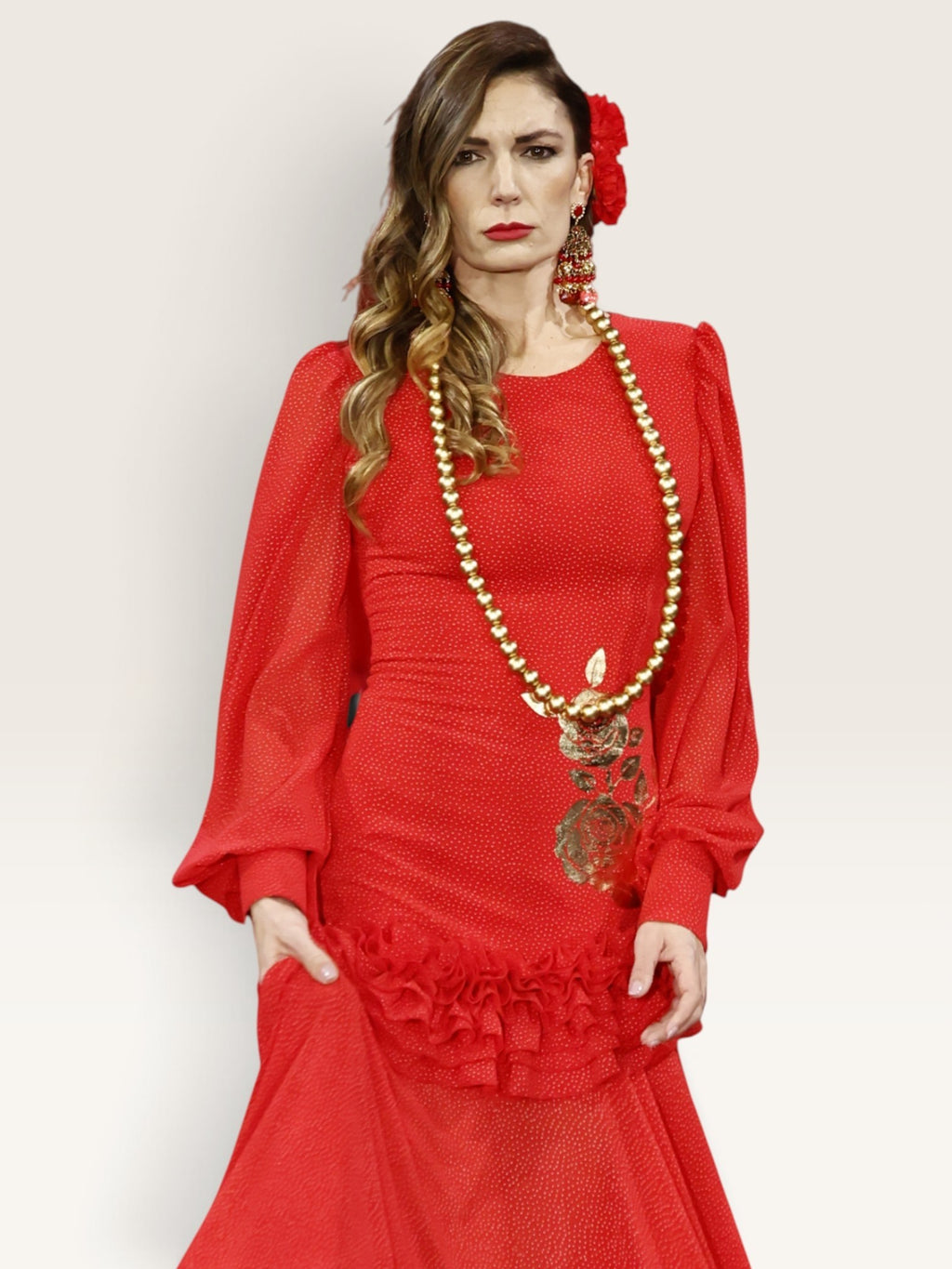 Modelo con vestido de gasa rojo Sergy & Tapiju con lunares blancos, detalle dorado y falda con movimiento.