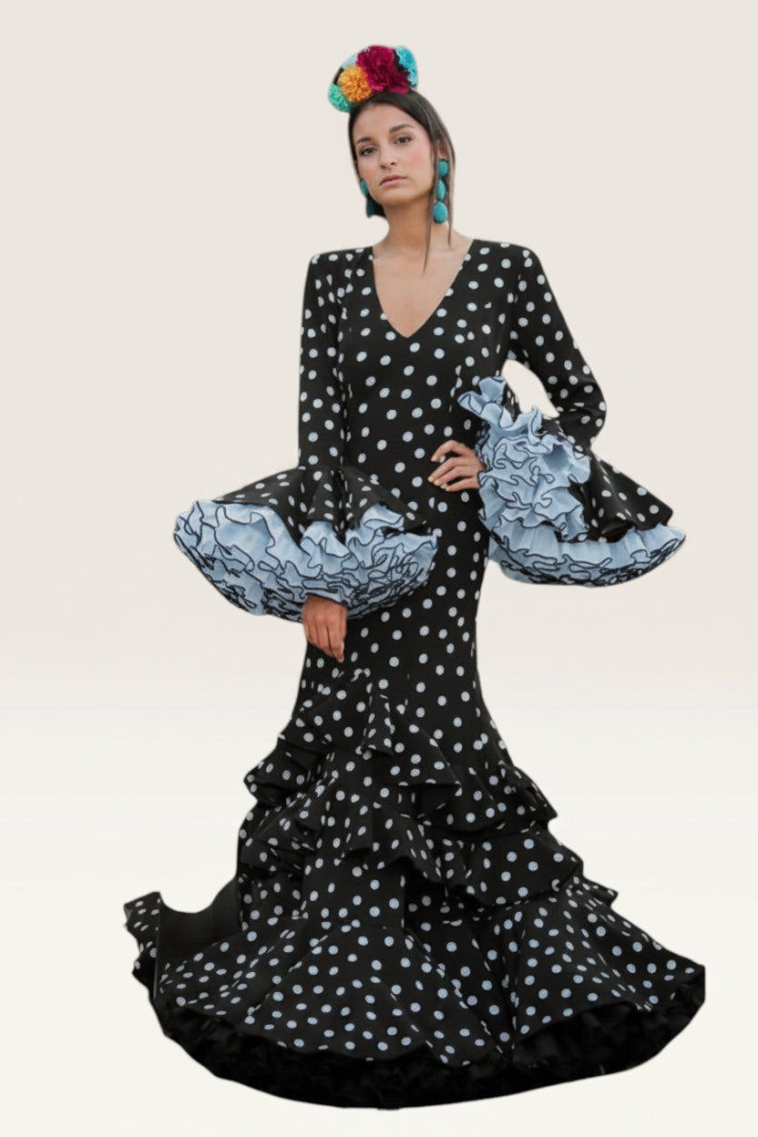 Modelo con vestido Sergy & Tapiju negro de lunares blancos, corte sirena, volantes en mangas y falda, estilo flamenco.
