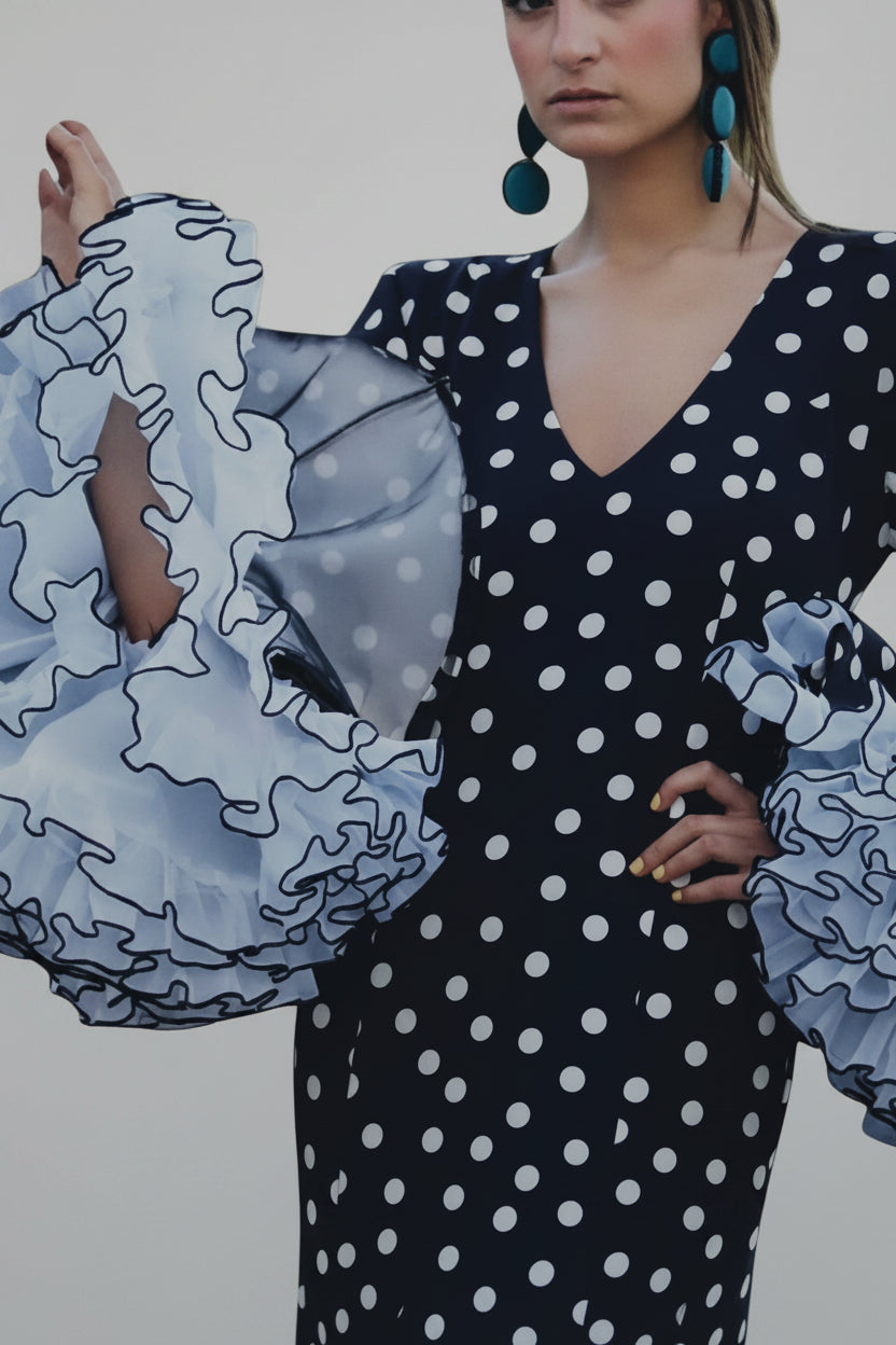 Modelo con vestido Sergy & Tapiju negro de lunares blancos, escote en V y mangas con volantes de estilo flamenco